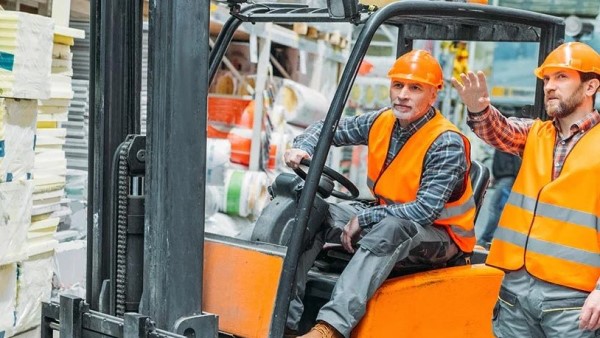 An image of a forklift operator and a pedestrian both wearing a safety vest